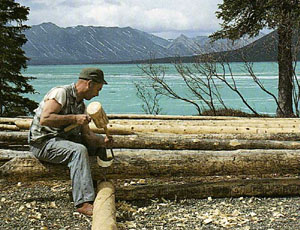 Dick Proenneke notching logs for the cabin walls